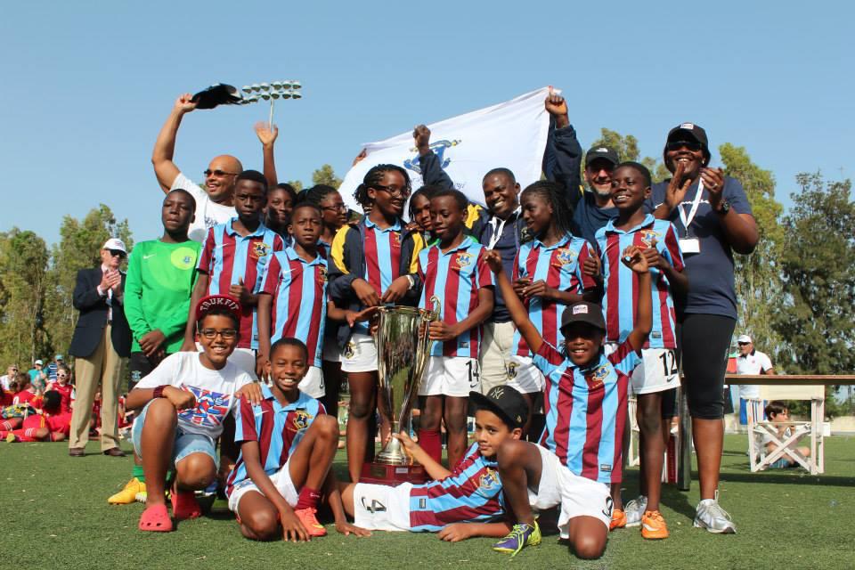 The St. Saviour's soccer team celebrating with their trophy, David in the green jersey