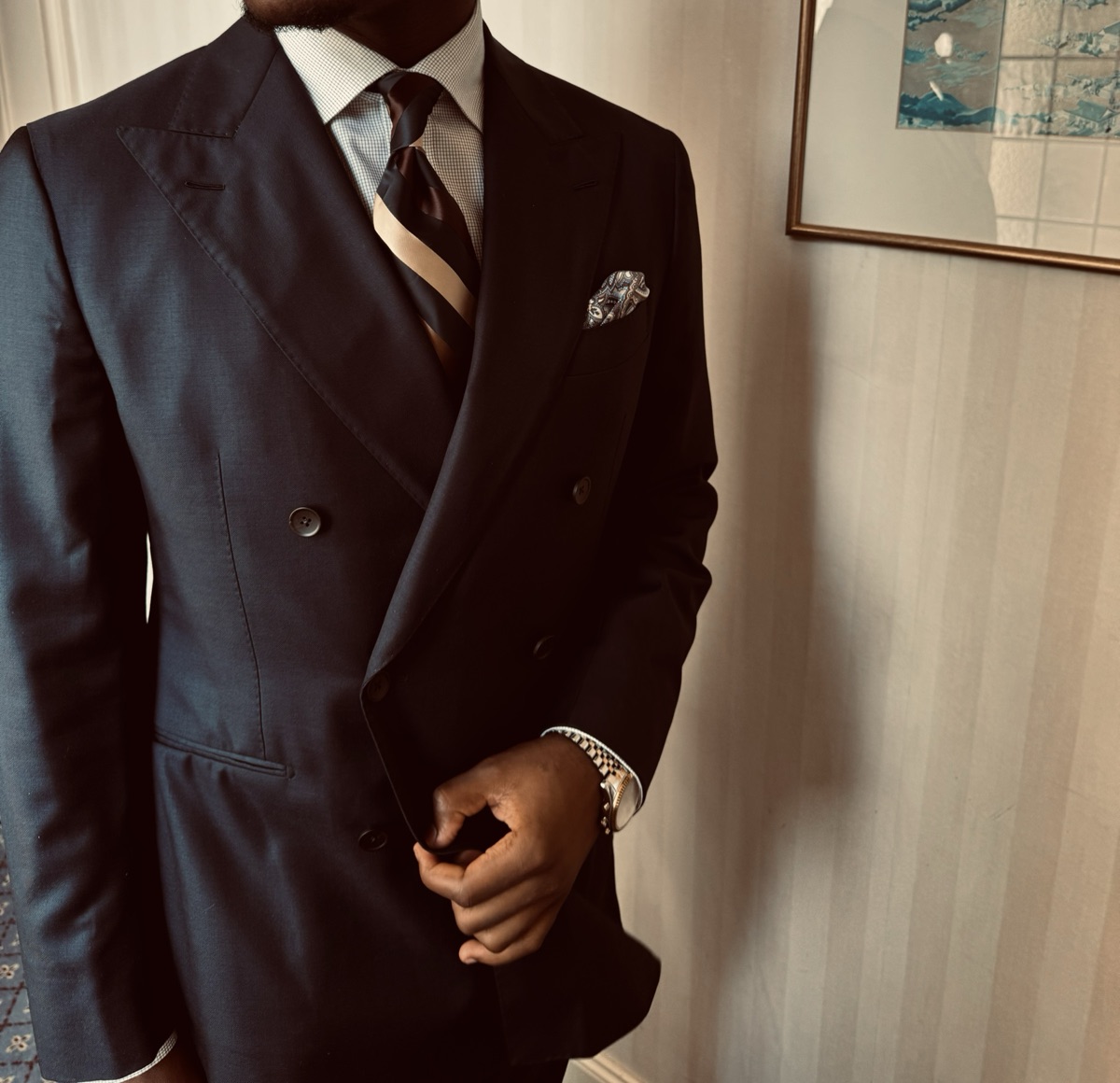 Detail of a double-breasted navy jacket, peak lapel and pocket square
