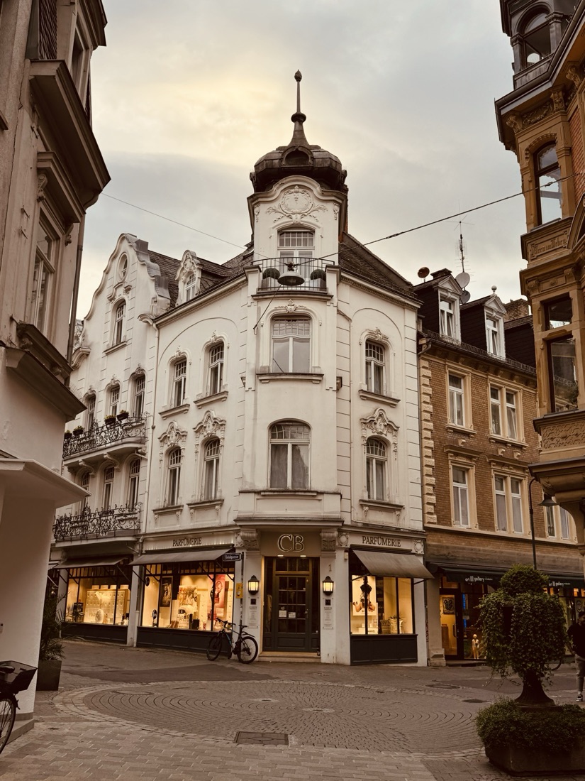 A parfumerie on an old European street corner at dusk
